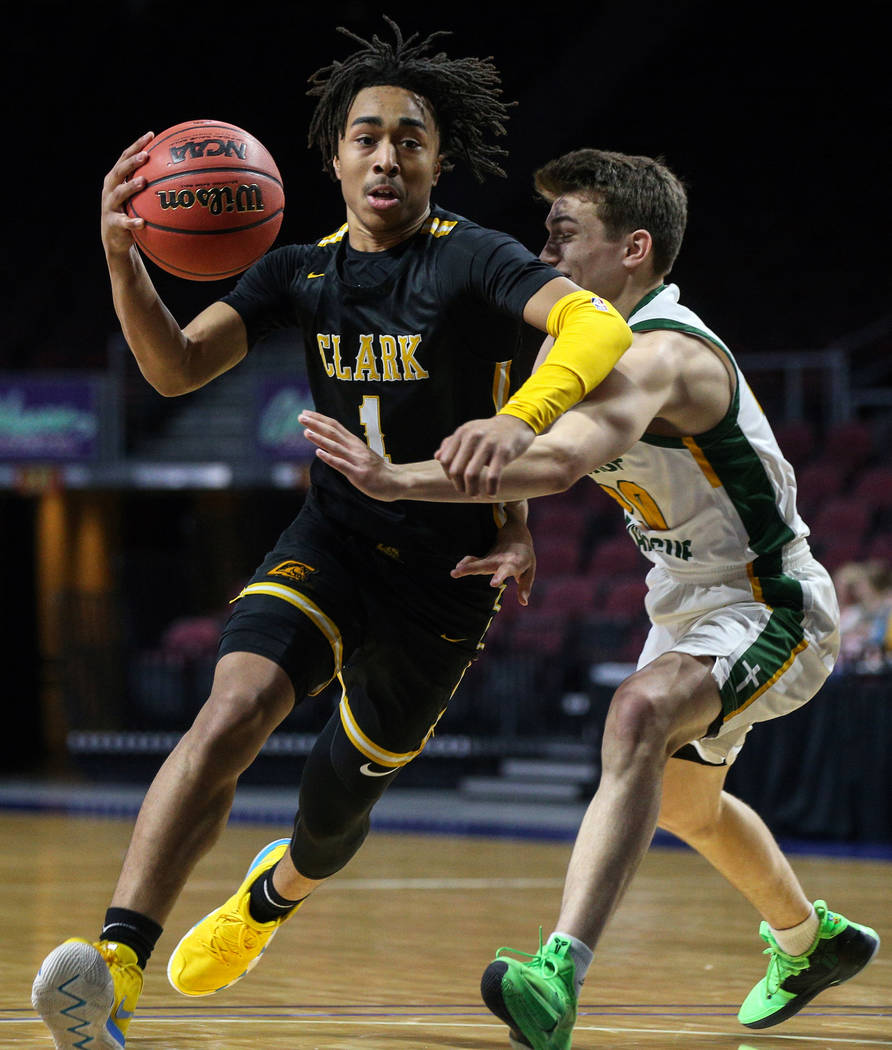 Clark's Frankie Collins (1) runs with the ball while being guarded by Bishop Manogue's Cort Ballinger (20) during the first half of a Class 4A state boys basketball semifinal game at the Orleans A ...