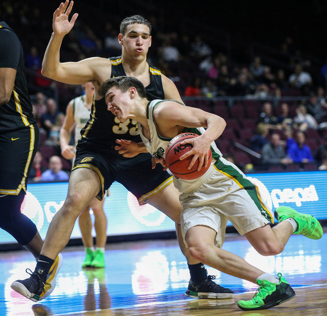 Bishop Manogue's Cort Ballinger (20) drives to the net with the ball while being guarded by Clark's Vincas Veikalas (33) during the second half of a Class 4A state boys basketball semifinal game a ...