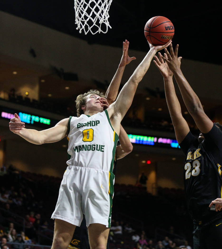 Bishop Manogue's Brayden Debruin (0) reaches up for the ball over Clark's Cameron Kimble-Carey (12) and Antwon Jackson (23) during the second half of a Class 4A state boys basketball semifinal gam ...