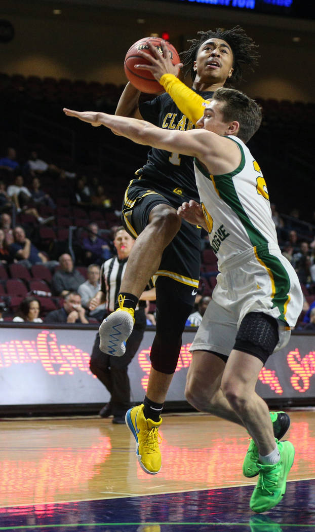 Clark's Frankie Collins (1) jumps up to take a shot while being guarded by Bishop Manogue's Cort Ballinger (20) during the first half of a Class 4A state boys basketball semifinal game at the Orle ...
