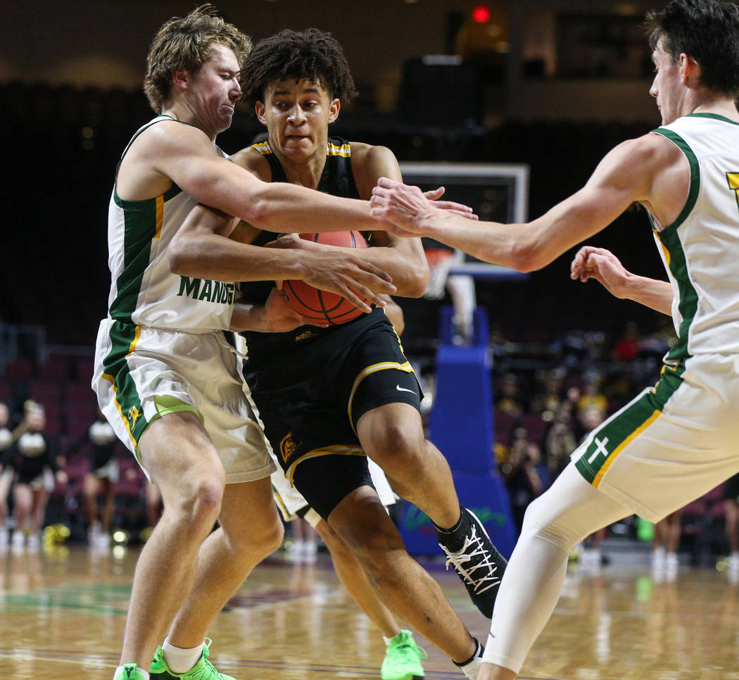 Clark's Jalen Hill (21) protects the ball from Bishop Manogue's Brayden Debruin (0) and Kolton Frugoli (10) during the first half of a Class 4A state boys basketball semifinal game at the Orleans ...