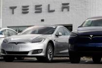 In this Sunday, July 8, 2018, photograph, 2018 Model 3 sedan sits next to a Model X on display outside a Tesla showroom in Littleton, Colo. (AP Photo/David Zalubowski)