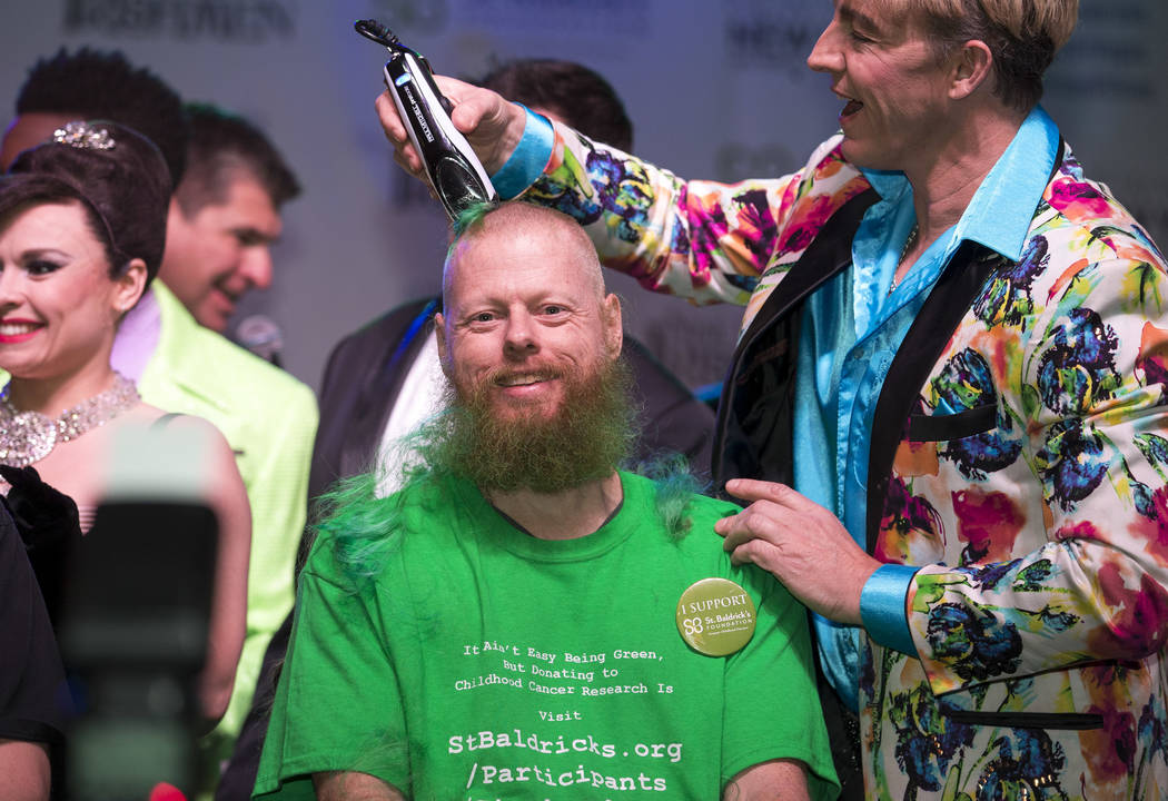 Ed Conte, a crew member for Cirque du Soleil's Zumanity, gets his head shaved during the St. Baldrick's head-shaving event to raise money for childhood cancer research outside the New York-New Yor ...
