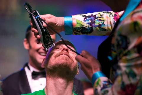 Ed Conte, a crew member for Cirque du Soleil's "Zumanity," gets his head shaved during the St. Baldrick's head-shaving event to raise money for childhood cancer research outside the New York-New Y ...