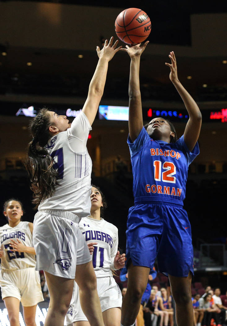 Bishop Gorman's Aaliyah Bey (12) reaches for the ball over Spanish Springs' Mariah Barraza (33) during the first half of a Class 4A state girls basketball semifinal game at the Orleans Arena in La ...