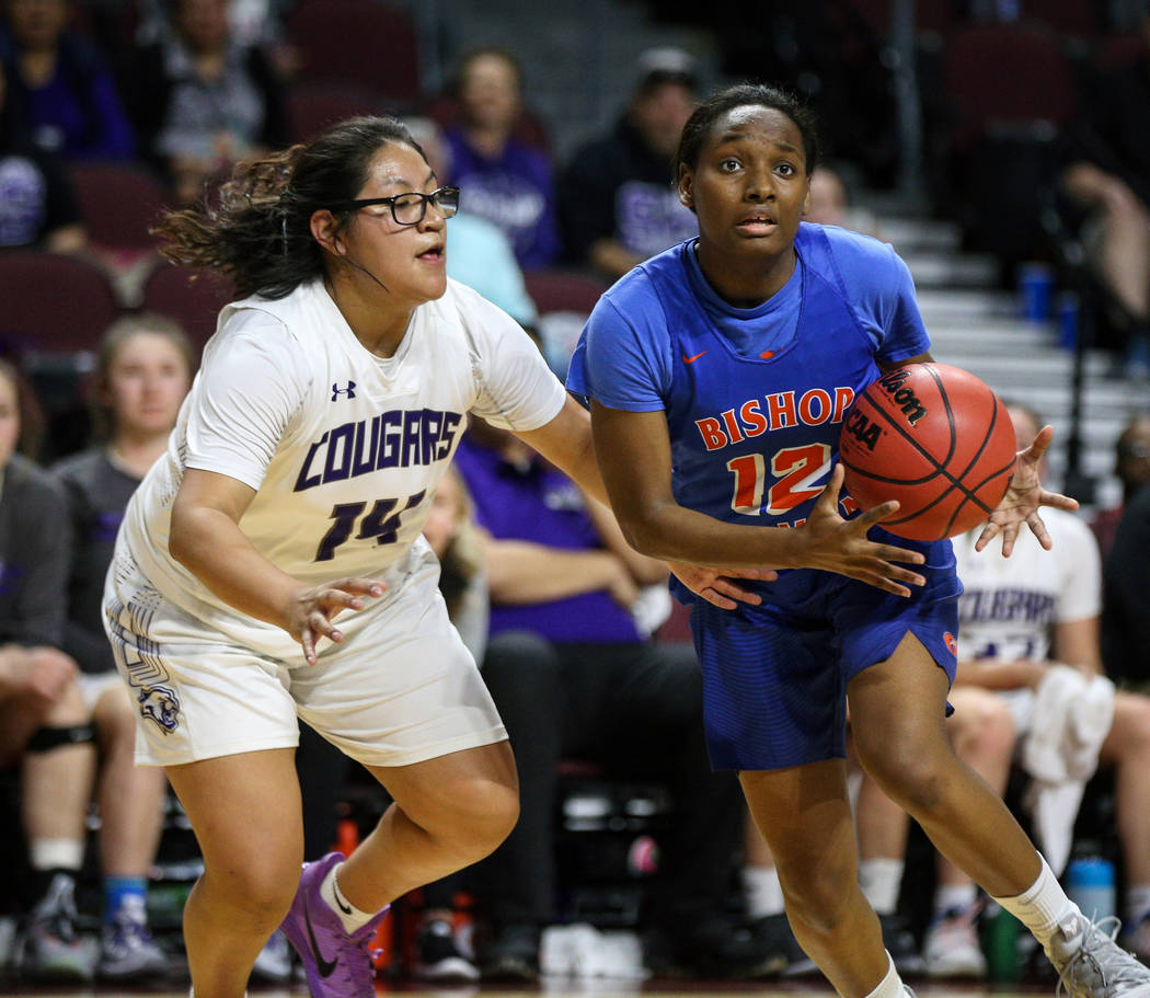 Bishop Gorman's Aaliyah Bey (12) looks to pass the ball while being guarded by Spanish Springs' Autumn Wadsworth (14) during the first half of a Class 4A state girls basketball semifinal game at t ...