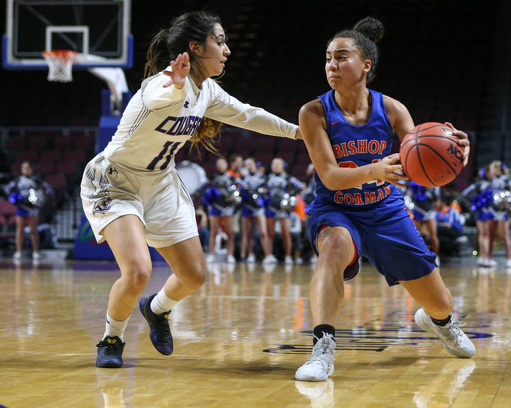 Bishop Gorman's Bentleigh Hoskins (24) looks to pass the ball while being guarded by Spanish Springs' Naelia Pinedo (11) during the first half of a Class 4A state girls basketball semifinal game a ...