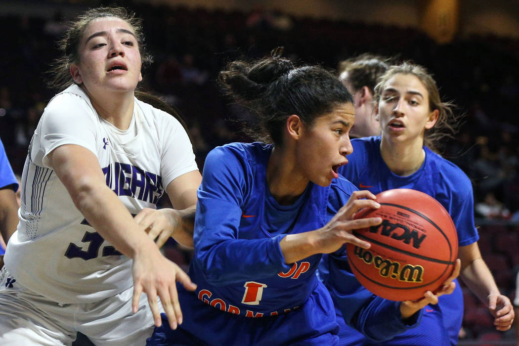 Bishop Gorman's Caira Young (1) protects the ball while being guarded by Spanish Springs' Mariah Barraza (33) during the second half of a Class 4A state girls basketball semifinal game at the Orle ...