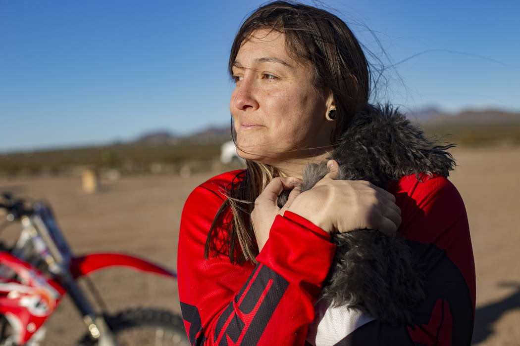 Angie Wright holds her dog Phoenix at Western Raceway track outside White Hills, Arizona, Sunday, Feb. 24, 2019. Wright will be racing in the Mint 400's motorcycle race, the first dirt bike race f ...