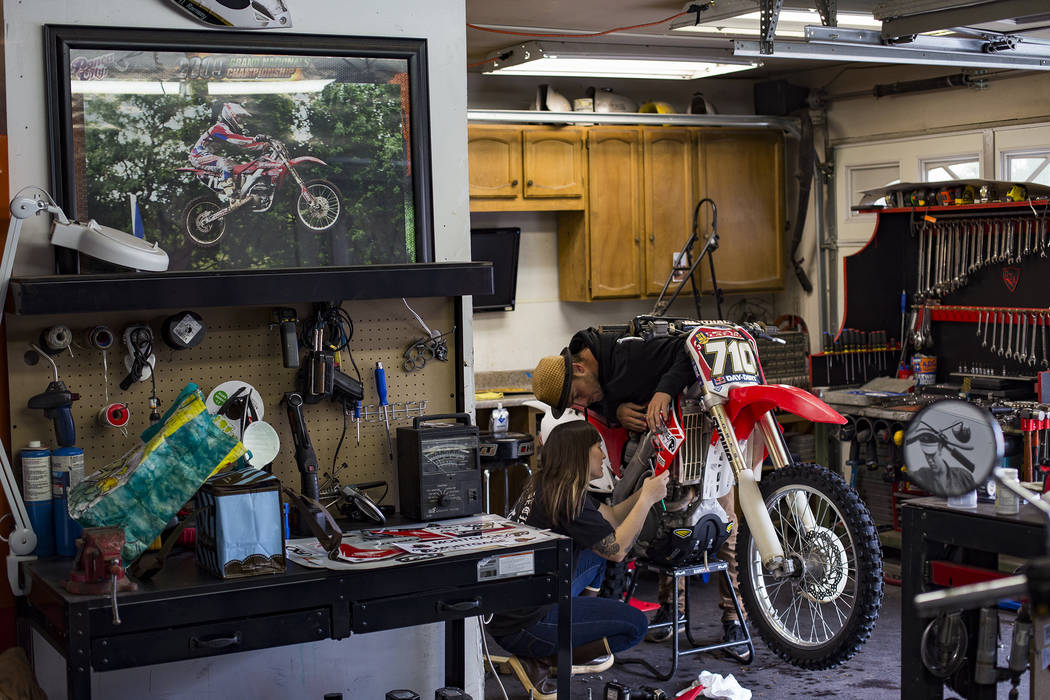 Angie Wright works on her bike with her boyfriend Derek Stephens at her father's home in Henderson, Wednesday, March 6, 2019. Wright will be racing in the Mint 400, the first dirt bike race for th ...