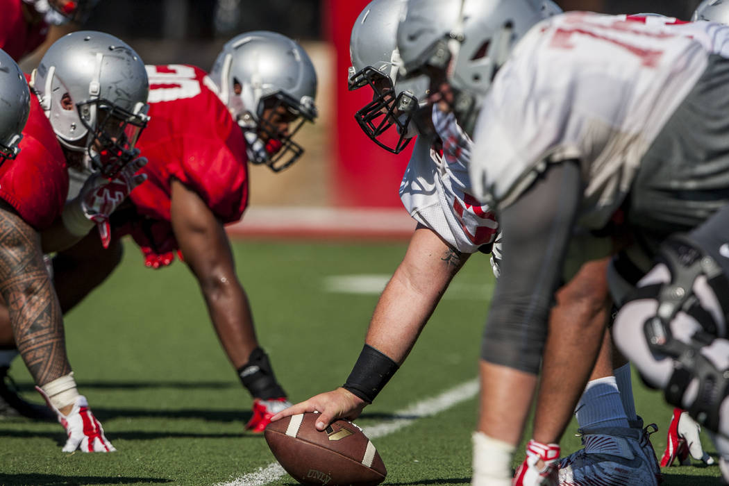 UNLV center Zack Singer, center, prepares to snap the ball while practicing a play during training camp at Rebel Park on Tuesday, Aug. 8, 2017. Patrick Connolly Las Vegas Review-Journal @PConnPie