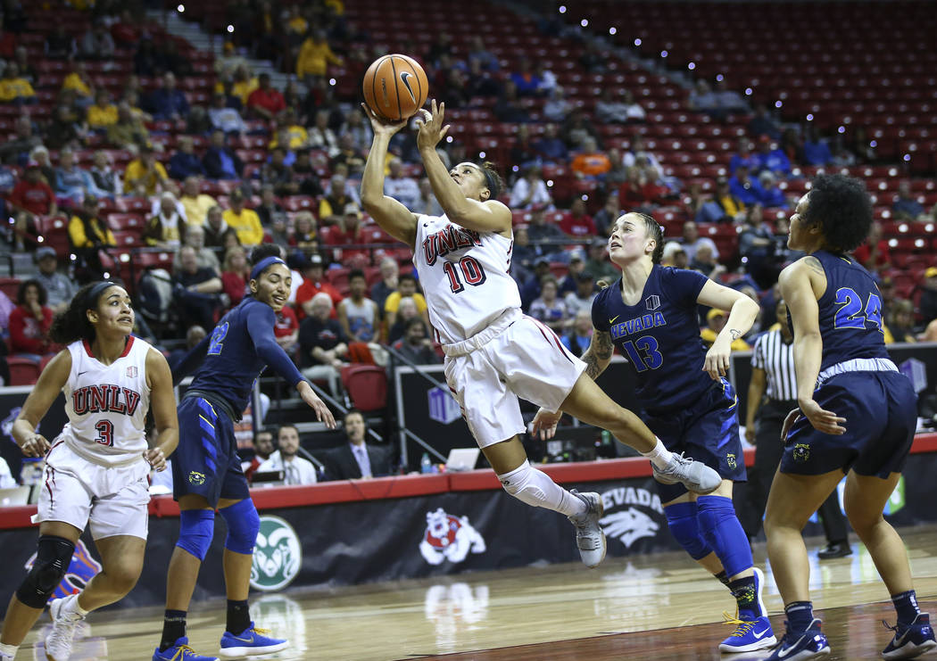 UNLV Lady Rebels guard Nikki Wheatley (10) sends up a shot past UNR Wolf Pack guard T Moe (13) during the second half of a basketball game in the Mountain West tournament quarterfinals at the Thom ...