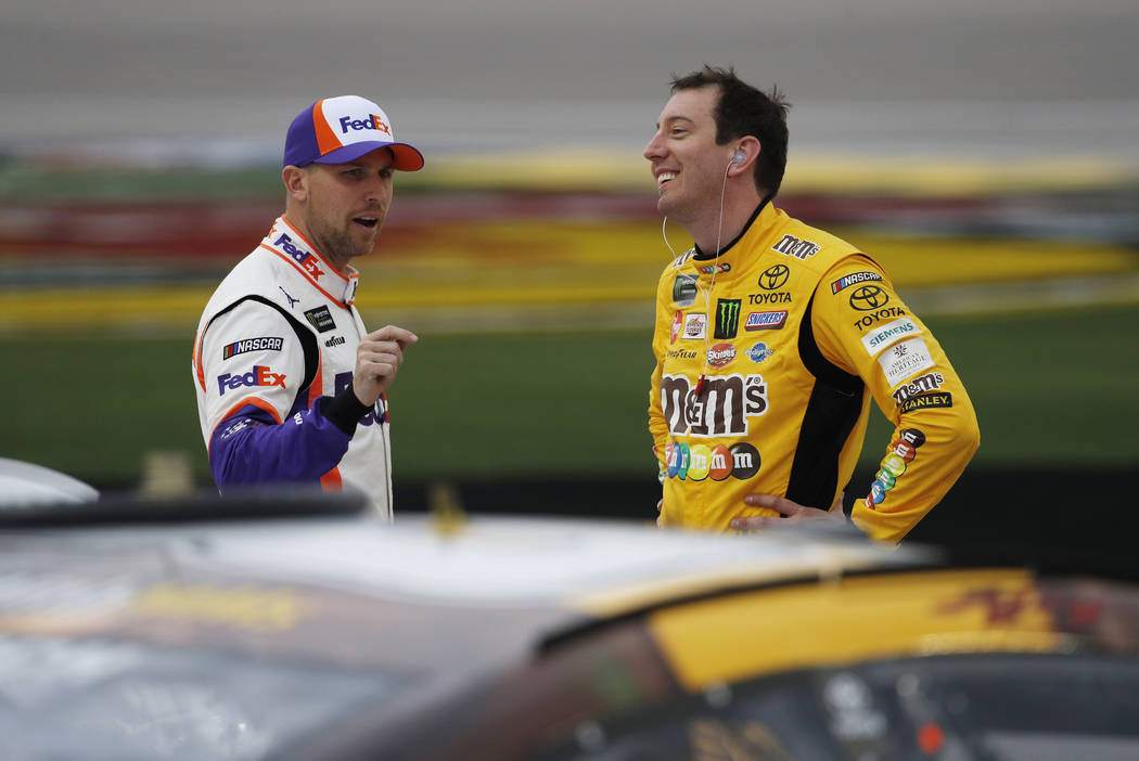 Denny Hamlin, left, and Kyle Busch talk in pit lane before qualifying for the NASCAR Cup Series auto race at Las Vegas Motor Speedway, Friday, March 1, 2019, in Las Vegas. (AP Photo/John Locher)