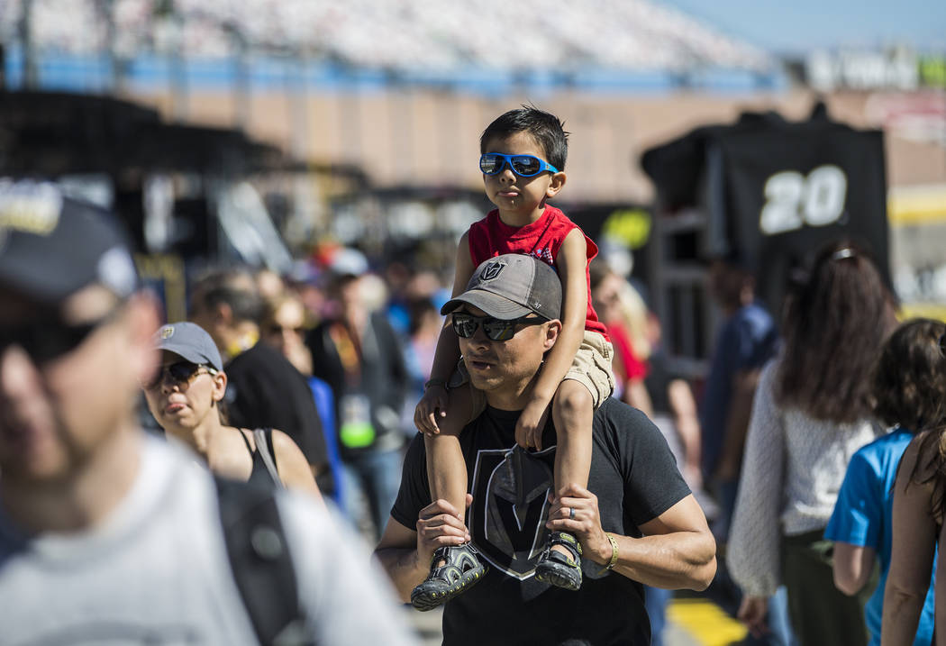 Robert Chavez carries son Ray, 5, in pit row before the start of the Monster Energy NASCAR Cup Series Pennzoil 400 on Sunday, March 3, 2019, at Las Vegas Motor Speedway, in Las Vegas. (Benjamin Ha ...