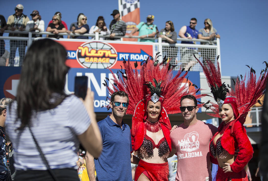 Shane O'Toole, left, and Bryan Baker take a photo with showgirls at the Monster Energy NASCAR Cup Series Pennzoil 400 on Sunday, March 3, 2019, at Las Vegas Motor Speedway, in Las Vegas. (Benjamin ...