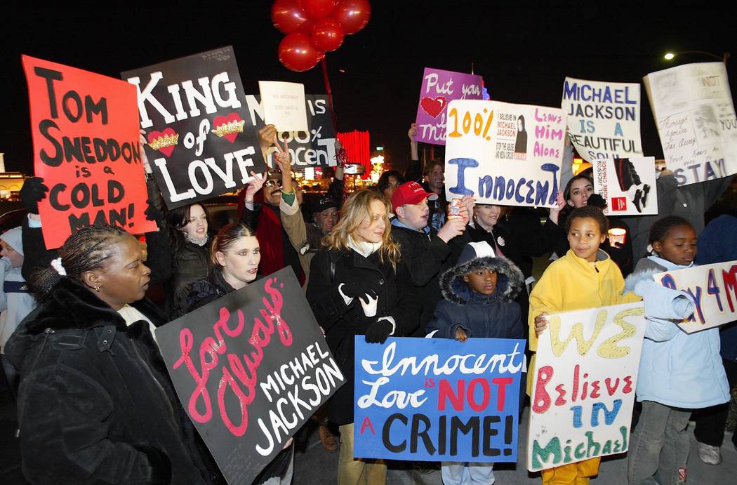 A small crowd of people hold up signs outside of the Las Vegas studio where Michael Jackson has been recently working Saturday, Nov. 22, 2003. Jackson had returned to Las Vegas Thursday after tur ...