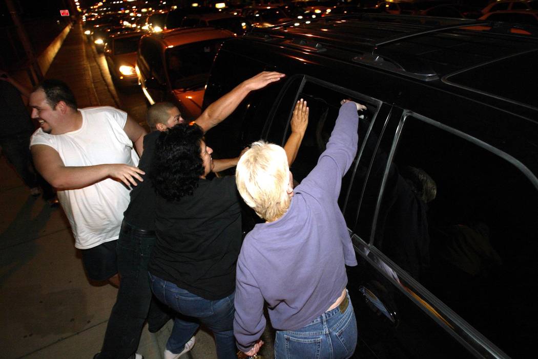 Michael Jackson fans try to touch the pop superstar through the window of his car Thursday, Nov. 20, 2003, after Jackson arrived back in Las Vegas after posting bail in Santa Barbara on child mole ...