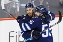 Winnipeg Jets' Kevin Hayes (12) and Mark Scheifele (55) celebrate Hayes' his first goal for the Jets since his recent trade to the team, against the Nashville Predators during the third period of ...