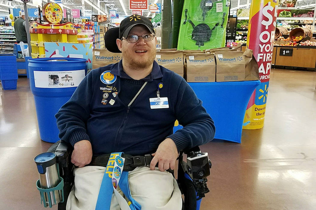 In this April 21, 2018 photo provided by Rachel Wasser, Walmart greeter John Combs works at a Walmart store in Vancouver, Wash. Combs, who has cerebral palsy, and other greeters with disabilities ...
