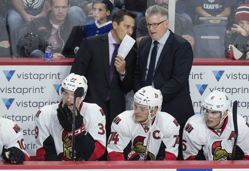 Ottawa Senators head coach Guy Boucher, left, speaks with assistant coach Marc Crawford during the third period of a preseason NHL hockey game in Halifax, Nova Scotia on Sept. 26, 2016. (Darren Ca ...