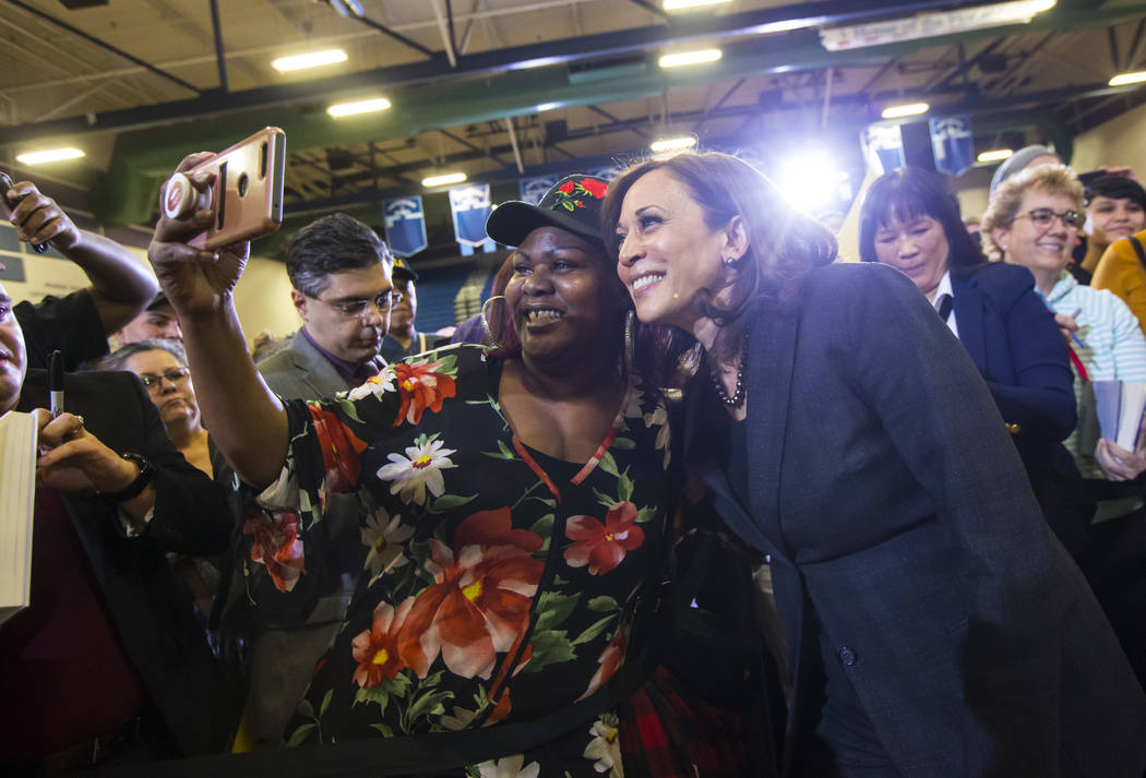 U.S. Sen. Kamala Harris, D-Calif., a Democratic presidential hopeful, right, poses for pictures with supporters during a campaign rally at Canyon Springs High School in North Las Vegas on Friday, ...