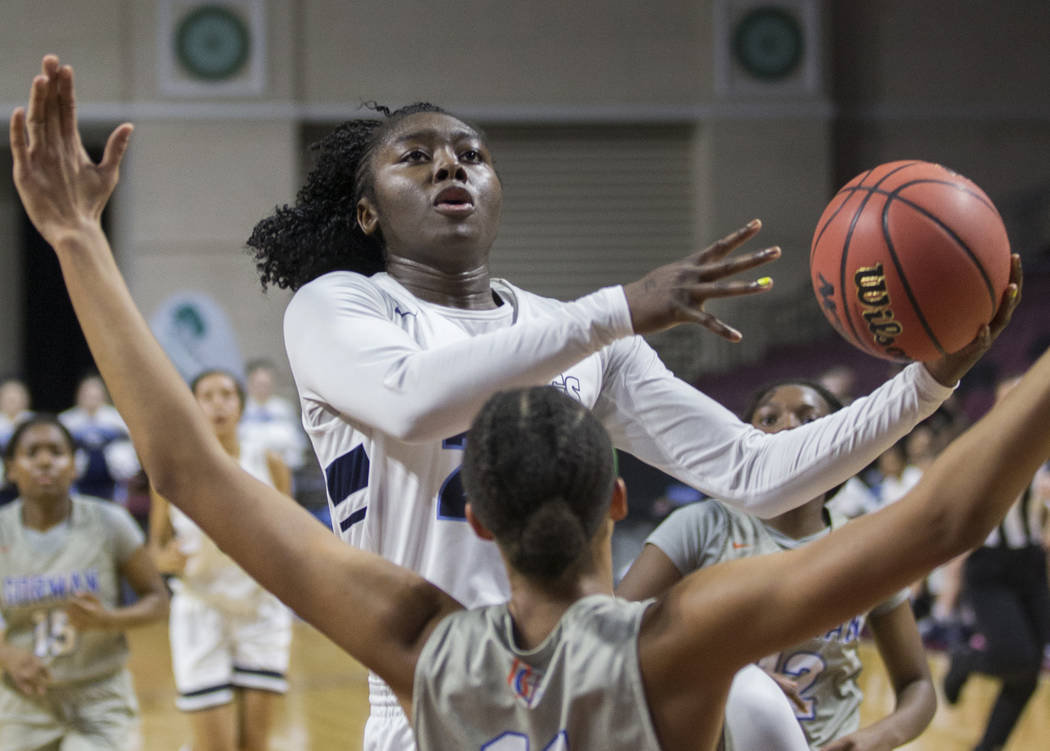 Centennial senior Eboni Walker (22) drives past Bishop Gorman senior Olivia Smith (11) in the first quarter of the Class 4A girls state championship game on Friday, March 1, 2019, at Orleans Arena ...