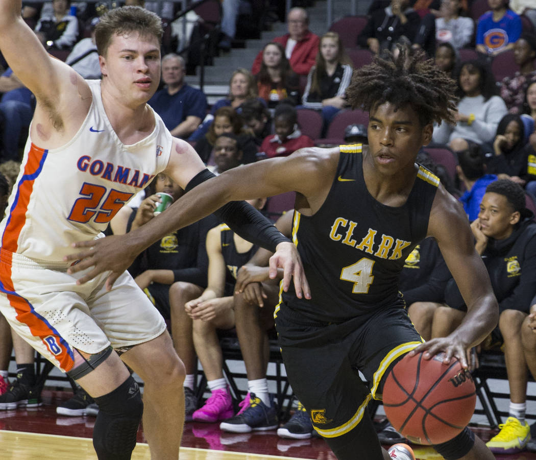 Clark senior guard Carlos Allen (4) drives baseline past Bishop Gorman senior guard Chance Michels (25) in the third quarter of the Class 4A boys state championship game on Friday, March 1, 2019, ...