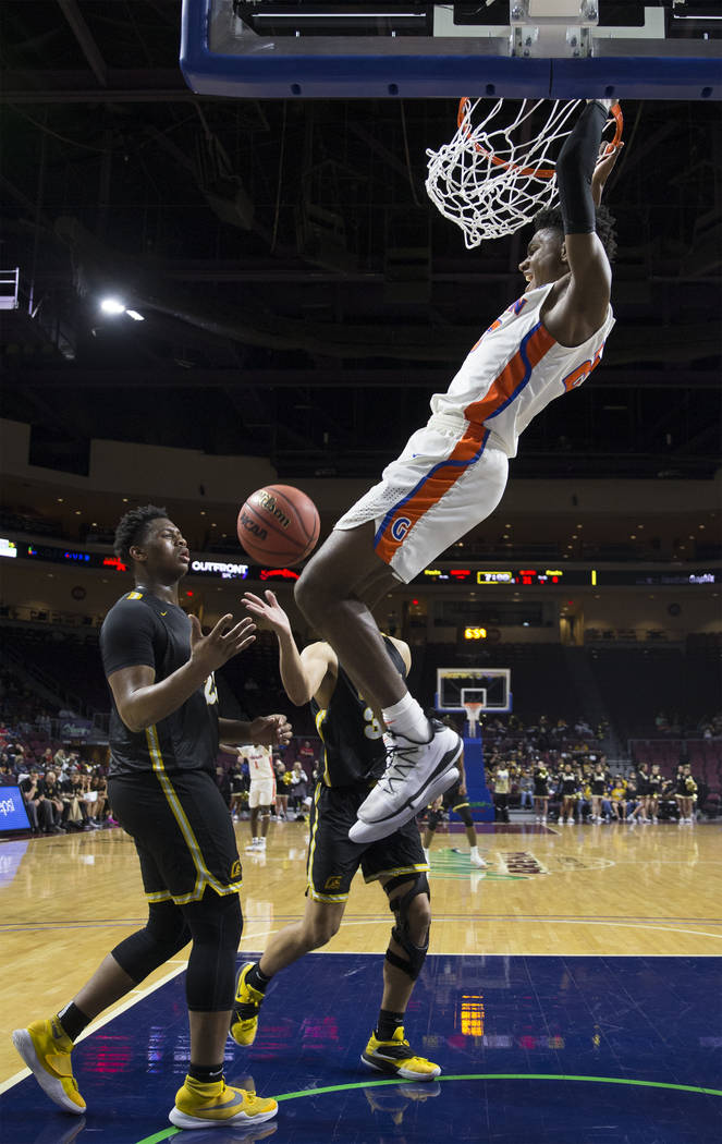 Bishop Gorman junior forward Mwani Wilkinson (23) dunks over Clark senior forward Antwon Jackson (23) in the third quarter of the Class 4A boys state championship game on Friday, March 1, 2019, at ...