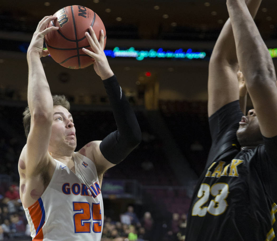 Bishop Gorman senior guard Chance Michels (25) drives over Clark senior forward Antwon Jackson (23) in the fourth quarter of the Class 4A boys state championship game on Friday, March 1, 2019, at ...