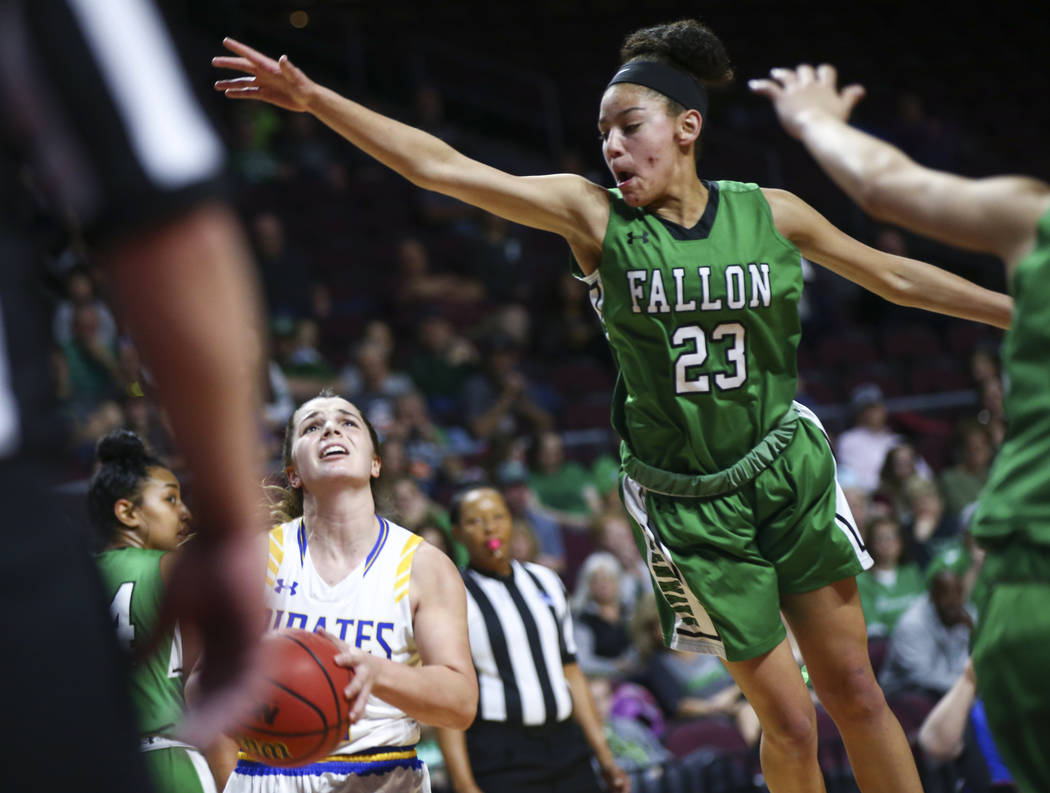 Moapa Valley's Lainey Cornwall, left, looks to shoot under pressure from Churchill County's Madison Whitaker (23) during the first half of the Class 3A girls basketball state championship game at ...