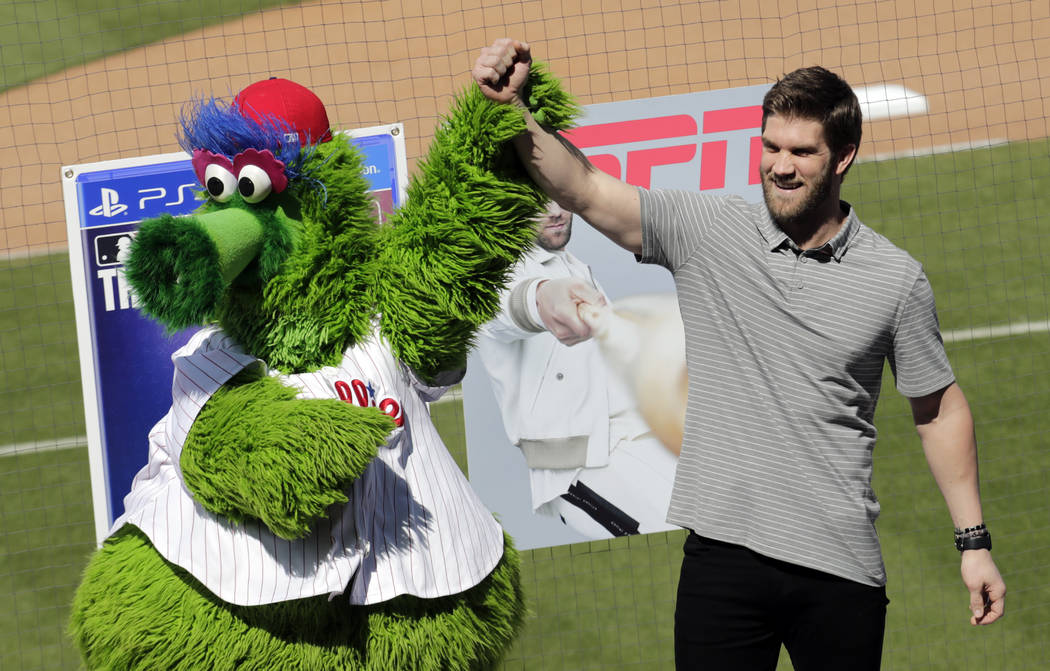 Bryce Harper stands with the Philadelphia Phillies mascot Phanatic before being introduced as a Phillies player during a news conference at the team's spring training baseball facility, Saturday, ...