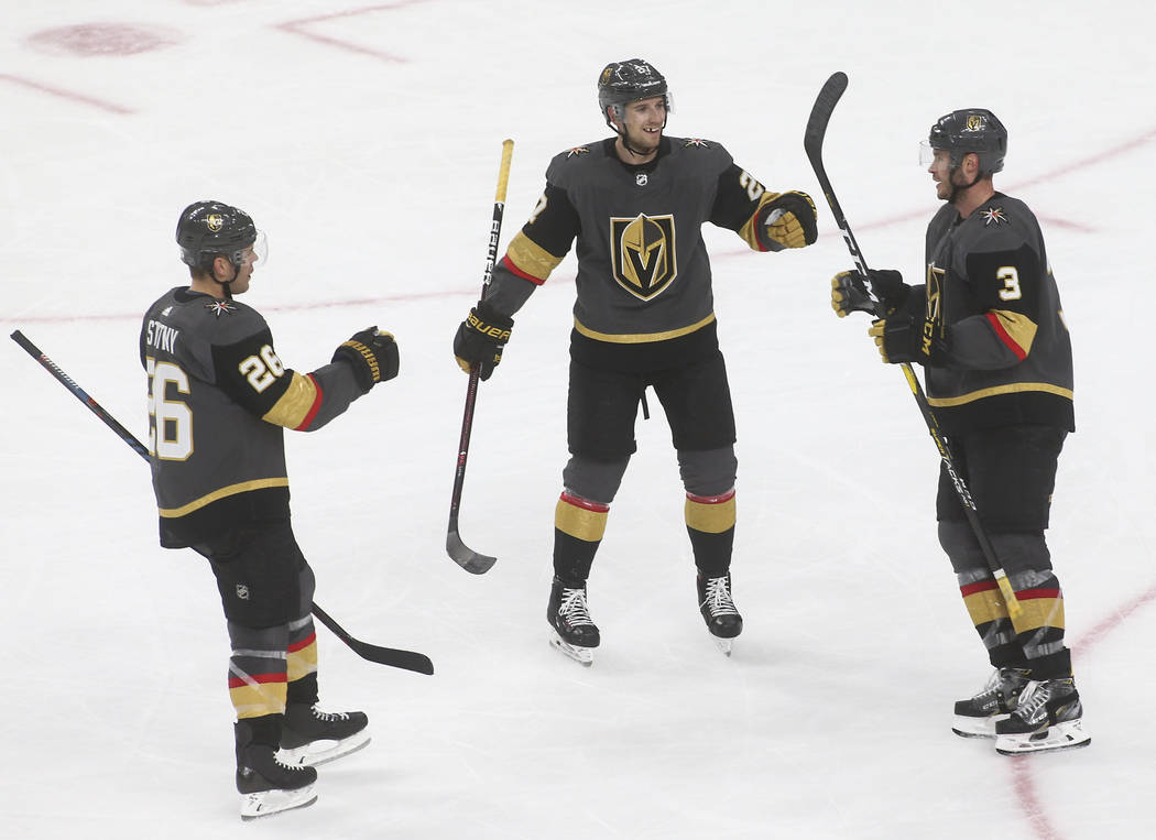 Golden Knights defenseman Brayden McNabb (3) celebrates his goal with Golden Knights center Paul Stastny (26) and Golden Knights defenseman Shea Theodore during the third period of an NHL hockey g ...