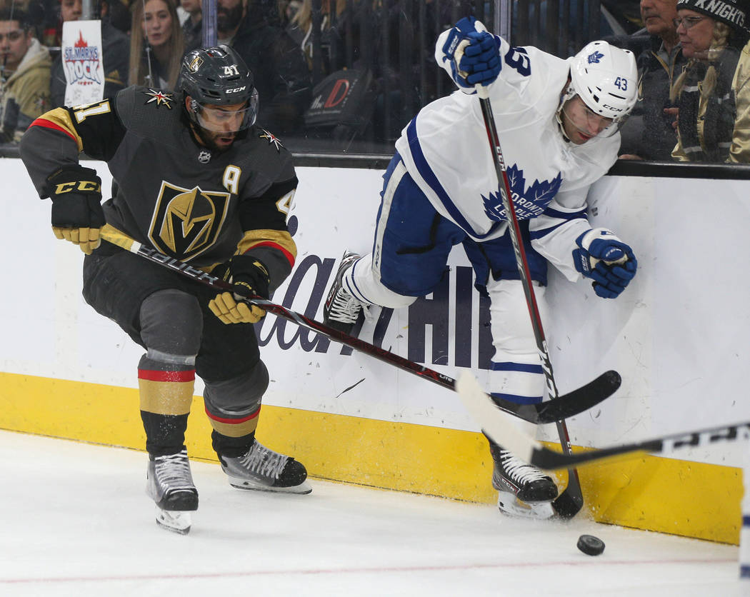 Vegas Golden Knights center Pierre-Edouard Bellemare (41) and Toronto Maple Leafs center Nazem Kadri (43) fight for the puck during the first period of an NHL hockey game at T-Mobile Arena in Las ...