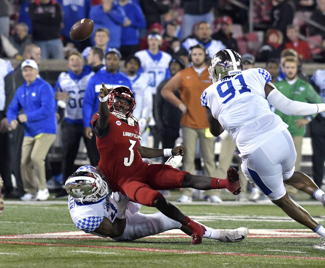 Louisville quarterback Malik Cunningham (3) attempts a pass while being brought down by Kentucky linebacker Josh Allen (41) during the first half of an NCAA college football game in Louisville, Ky ...