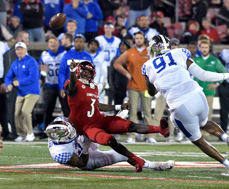 Louisville quarterback Malik Cunningham (3) attempts a pass while being brought down by Kentucky linebacker Josh Allen (41) during the first half of an NCAA college football game in Louisville, Ky ...