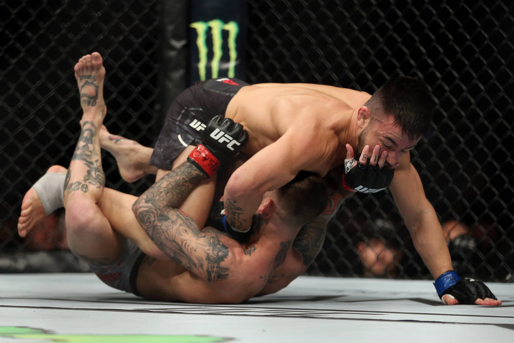 Pedro Munhoz, top, battles Cody Garbrandt in the first round of the bantamweight bout during UFC 235 at T-Mobile Arena in Las Vegas, Saturday, March 2, 2019. Munhoz won by way of knockout in the f ...
