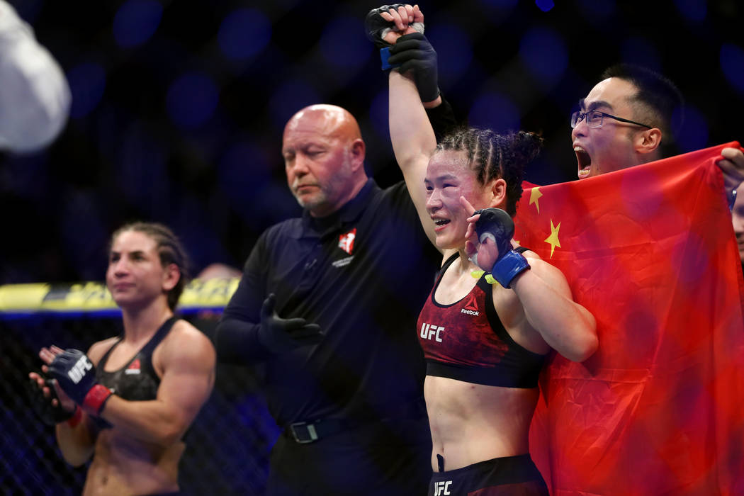 Weili Zhang, right, raises her hand in victory by unanimous decision against Tecia Torres in the womenÕs strawweight bout during UFC 235 at T-Mobile Arena in Las Vegas, Saturday, March 2, 201 ...