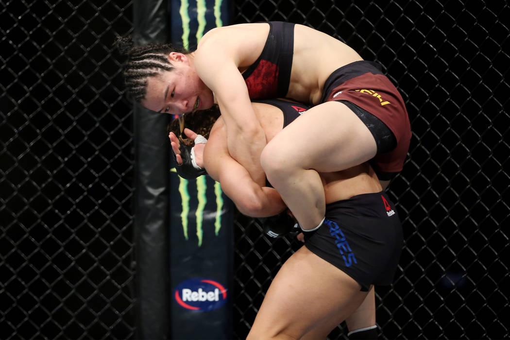 Weili Zhang, top, grabs to Tecia Torres in the womenÕs strawweight bout during UFC 235 at T-Mobile Arena in Las Vegas, Saturday, March 2, 2019. Zhang won by unanimous decision. (Erik Verduzco ...