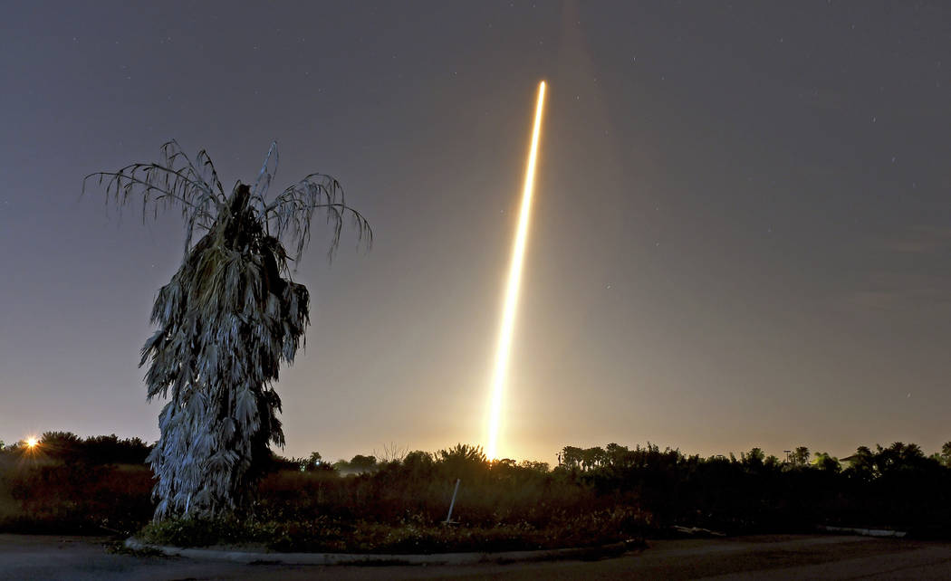 The SpaceX Falcon 9 rocket and Crew Dragon capsule launch from NASA pad 39A as seen in a time exposure from Viera, FL. on March 2 with a lone, untrimmed palm tree in the foreground. (Tim Shortt/Fl ...