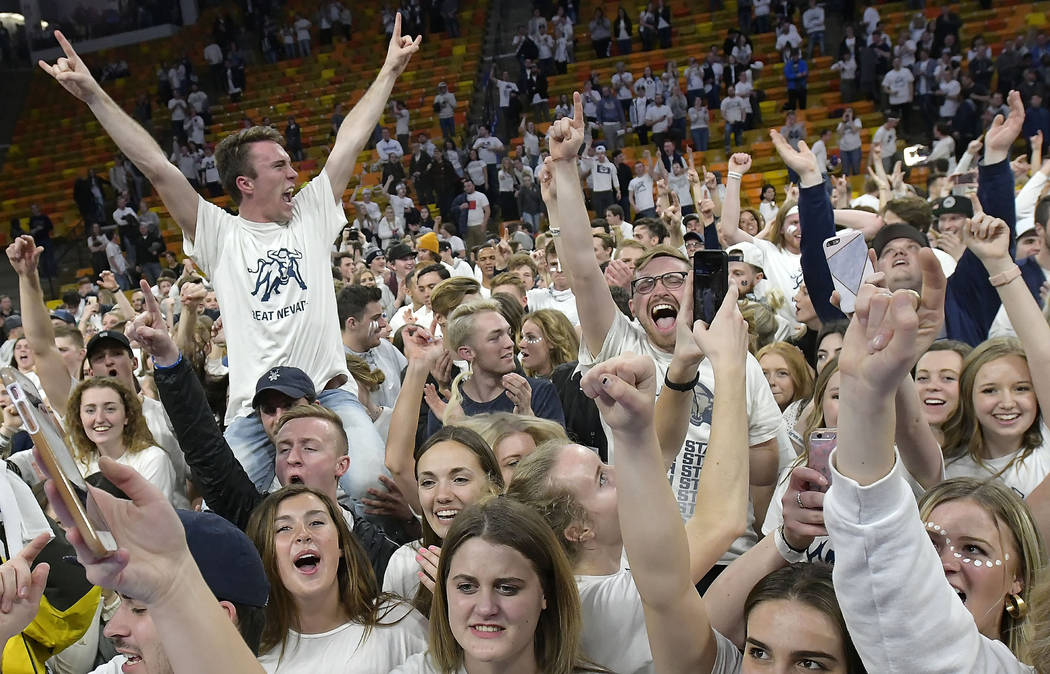 Fans celebrate on the court after Utah State defeated No. 12 Nevada 81-76 in an NCAA college basketball game Saturday, March 2, 2019, in Logan, Utah. (Eli Lucero/The Herald Journal via AP)