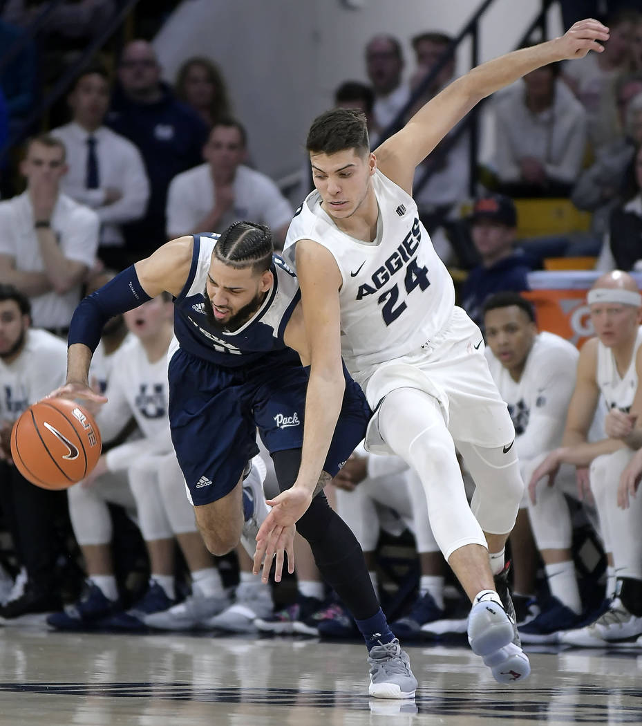 Nevada forward Cody Martin (11) gets fouled by Utah State guard Diogo Brito (24) during an NCAA college basketball game Saturday, March 2, 2019, in Logan, Utah. (Eli Lucero/The Herald Journal via AP)