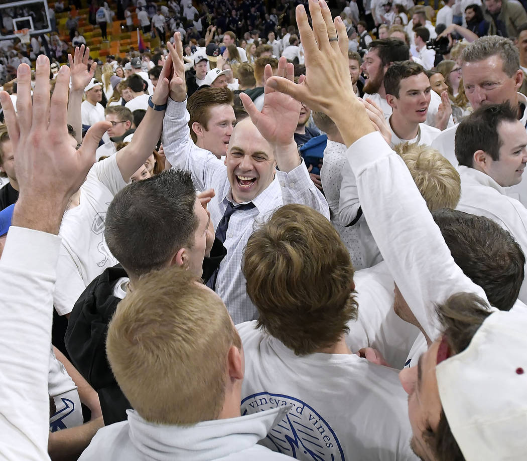 Utah State coach Craig Smith celebrates with fans on the court after Utah State defeated No. 12 Nevada 81-76 in an NCAA college basketball game Saturday, March 2, 2019, in Logan, Utah. (Eli Lucer ...