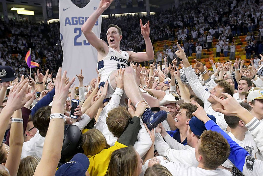 Fans celebrate with Utah State forward Justin Bean on the court after Utah State defeated Nevada 81-76 in an NCAA college basketball game Saturday, March 2, 2019, in Logan, Utah. (Eli Lucero/The H ...