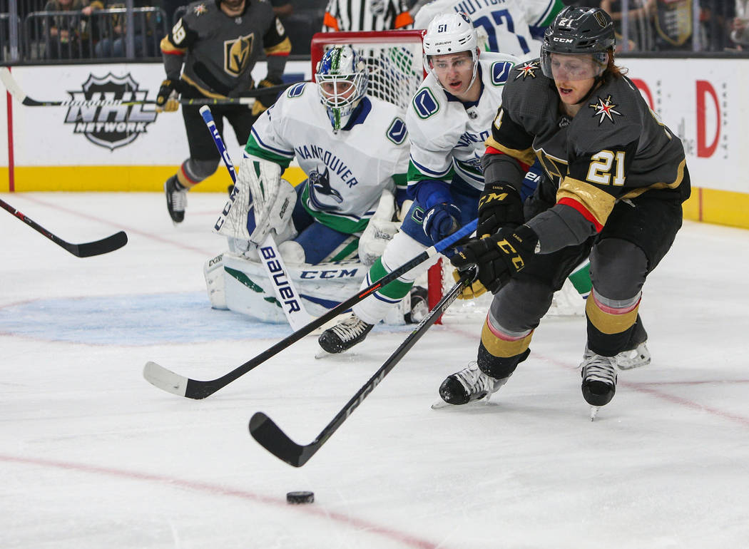 Vegas Golden Knights center Cody Eakin (21) skates with the puck as Vancouver Canucks defenseman Troy Stecher (51) trails close behind during the first period of an NHL hockey game at T-Mobile Are ...