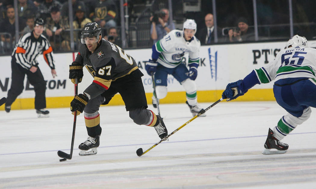Vegas Golden Knights left wing Max Pacioretty (67) looks to pass the puck as Vancouver Canucks defenseman Alex Biega (55) reaches behind during the first period of an NHL hockey game at T-Mobile A ...