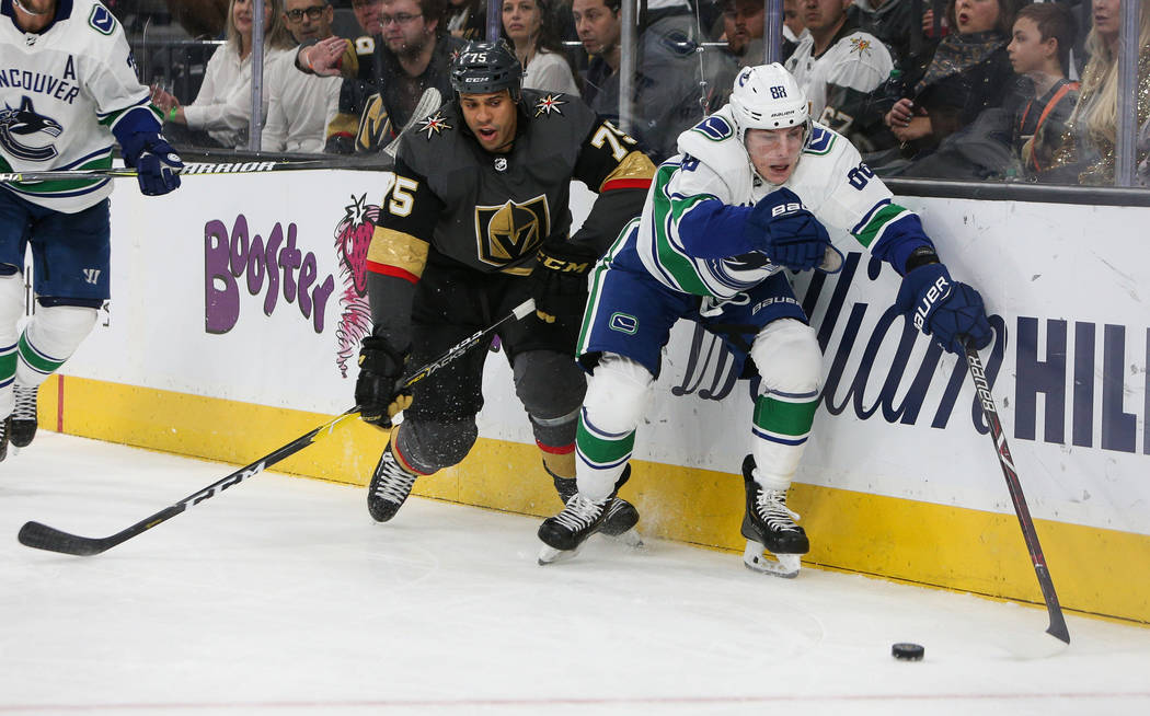 Vancouver Canucks center Adam Gaudette (88) reaches out for the puck as Vegas Golden Knights right wing Ryan Reaves (75) trails close behind during the third period of an NHL hockey game at T-Mobi ...