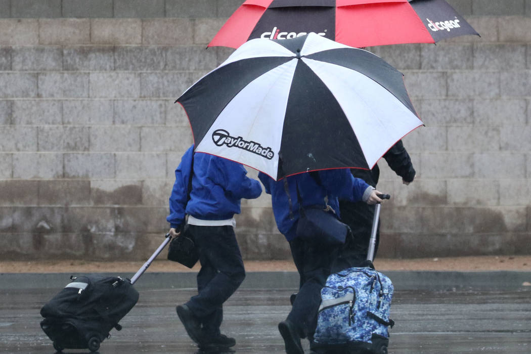 Pedestrians walk along Eastern Avenue during rainy morning commute on Thursday, Feb. 14, 2019, in North Las Vegas. (Bizuayehu Tesfaye/Las Vegas Review-Journal) @bizutesfaye