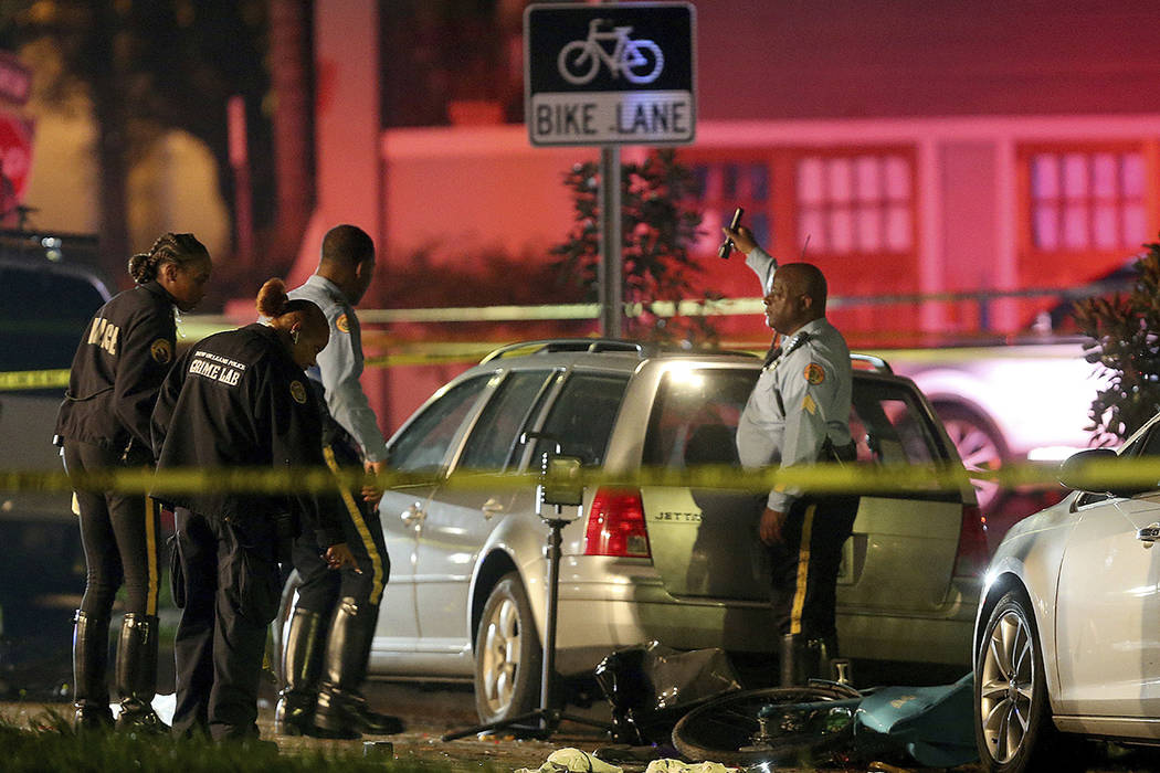 New Orleans Police examine damaged cars and bicycles on Esplanade Avenue in New Orleans after a car struck multiple people, killing several and injuring others following the Endymion Mardi Gras pa ...