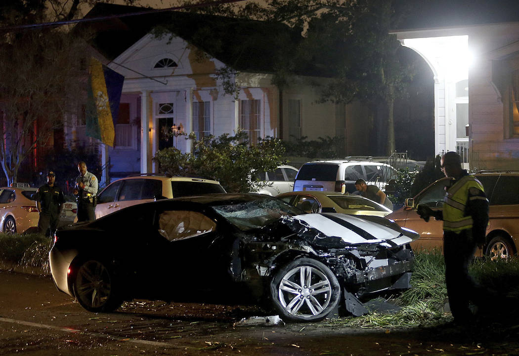 New Orleans Police examine a Chevy Camaro on Esplanade Avenue in New Orleans that struck multiple people, killing several and injuring others, after the Endymion Mardi Gras parade finished passing ...