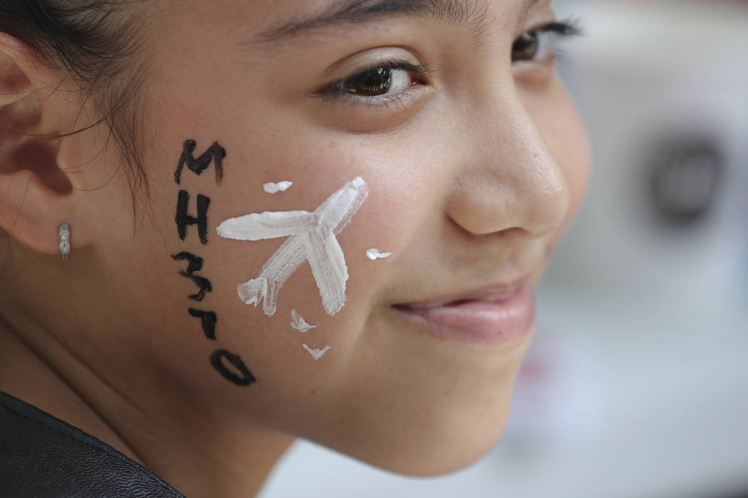 A girl has her face painted with a missing plane during a Day of Remembrance for MH370 event in Kuala Lumpur, Malaysia, Sunday, March 3, 2019. Five years ago, Malaysia Airlines Flight MH370, a Boe ...